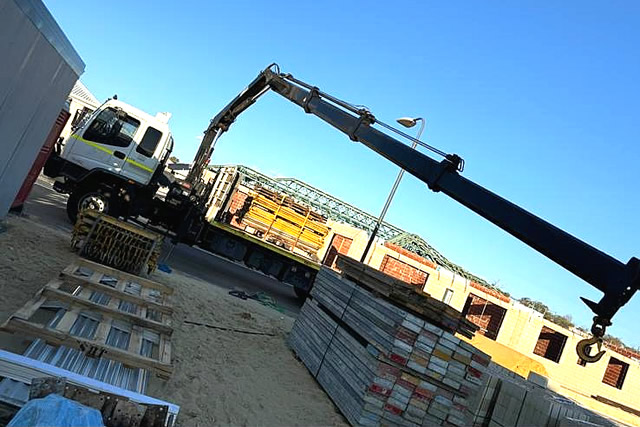 crane truck unloading building materials